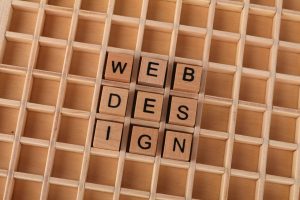 Wooden blocks spelling web design on a grid background symbolizing creative digital design concepts.